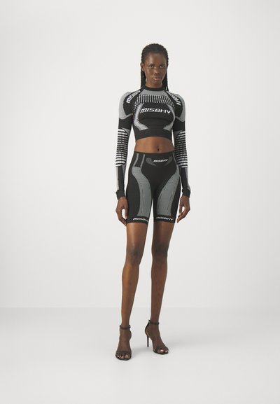 Schwarzes Sportoutfit mit einem kurzen Langarmoberteil und enganliegenden Shorts, die strukturierte Muster und weiße Logoakzente aufweisen.