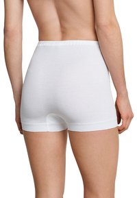 White cotton boyshorts with a soft, elastic waistband, featuring a snug fit and smooth texture, cut to mid-thigh length.