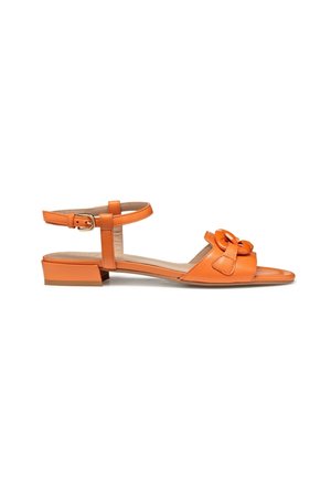 Oranje platte sandaal met enkelbandje, lage blokhak en gevlochten detail op het voorste bandje, zijaanzicht op een witte achtergrond.