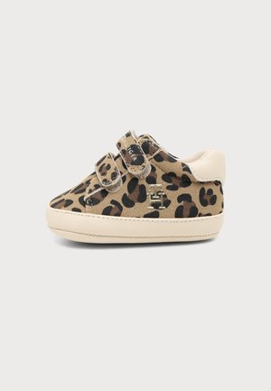 Beżowy dziecięcy sneaker z czarnym i brązowym nadrukiem w panterkę, dwoma paskami na rzep i białą podeszwą oraz naszywką na pięcie.