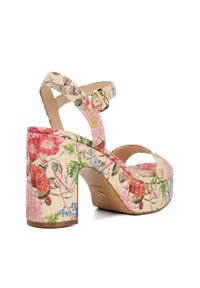 Sandale à talon haut à motifs floraux avec un talon épais, tige textile douce, sangle réglable et détails en boucle dorée.