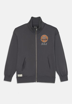 Tamno siva dukserica na zip s visokim ovratnikom, s vezanim logotipom na prsima i dva prednja dzepa. Mekana tekstura s rebrastim manžetama.