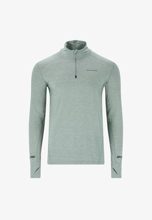 Maglia atletica a maniche lunghe verde chiaro con zip a metà collo, con accenti neri e logo, realizzata in un materiale texturizzato.