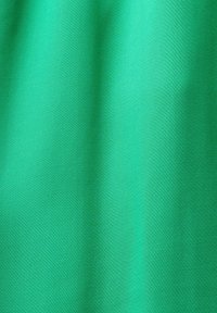 Tela verde brillante con una textura suave, que presenta pliegues sutiles y un color sólido y consistente sin patrones ni detalles metálicos.