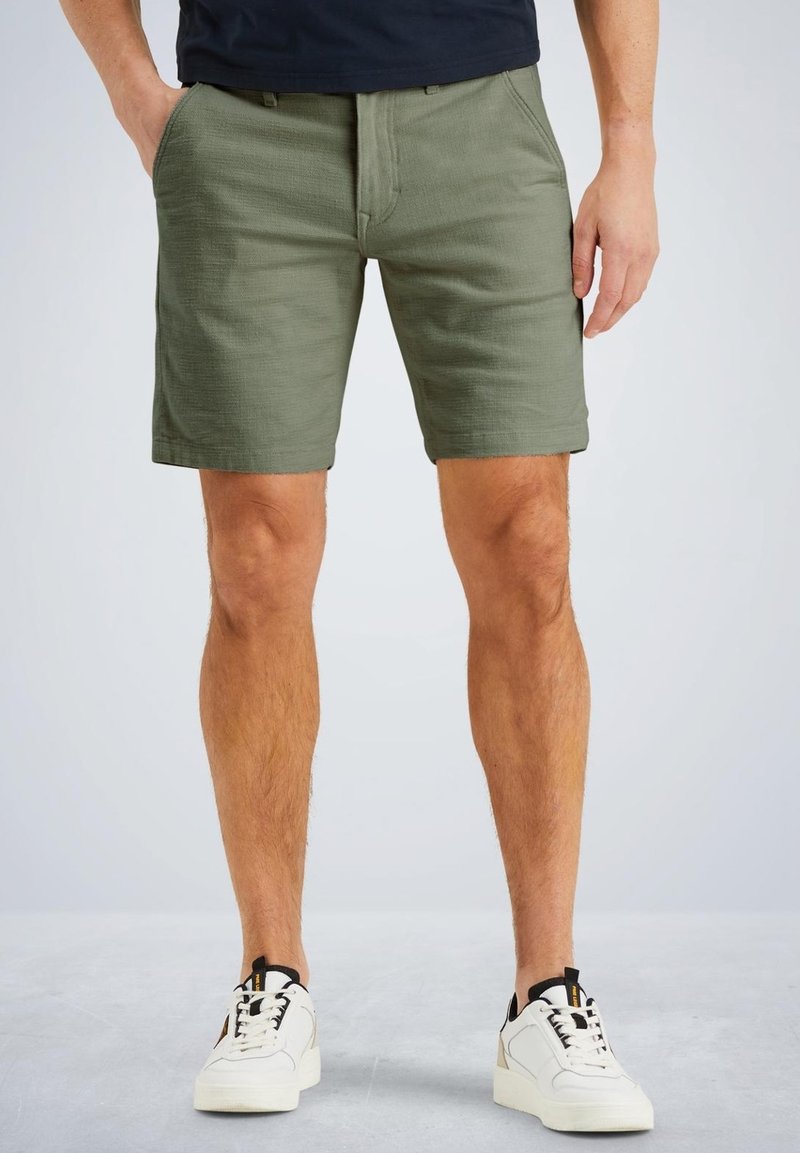 Shorts verts en tissu léger, avec une surface texturée, deux poches avant et une coupe droite classique au-dessus du genou.