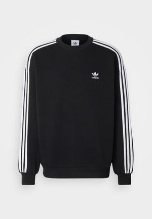 Svart hoodie med vitt tre-stripesmönster på ärmarna, rund hals, ribbade ärmslut och liten vit Adidas-logotyp på bröstet.