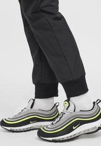 Nike Air Max 97 tenisice imaju crnu, sivu i neonsko žutu paletu boja s valovitim dizajnom, prozračnom mrežicom i zračnim jastučićima.