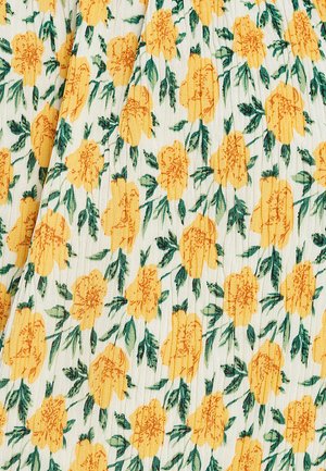 Blumenstoff mit gelben Ringelblumen auf weißem Hintergrund, umgeben von grünen Blättern; die Textur wirkt weich und leicht gerippt.