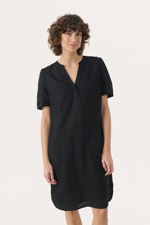 Robe en lin noire avec un décolleté en V, des manches courtes et des poches latérales. Le tissu présente une texture douce et une silhouette décontractée.