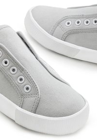 Graue Canvas-Slipper mit strukturiertem Obermaterial, runder Zehenpartie und weißen Gummisohlen mit gerippten Akzenten. Sechs Metallösen für Schnürsenkel.