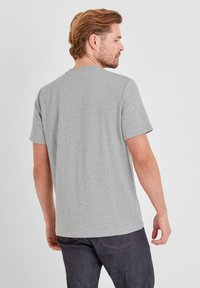 Gray cotton t-shirt with short sleeves, round neckline, and a relaxed fit. Visible stitching detail along the seams and shoulders.