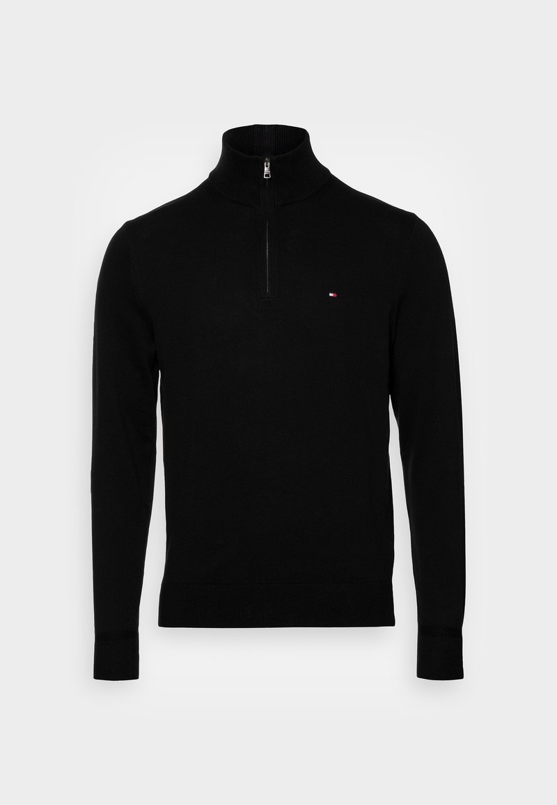 Pull noir à manches longues avec col montant, demi-fermeture éclair, poignets et ourlet côtelés, et petit logo rectangulaire rouge, blanc et bleu sur la poitrine.