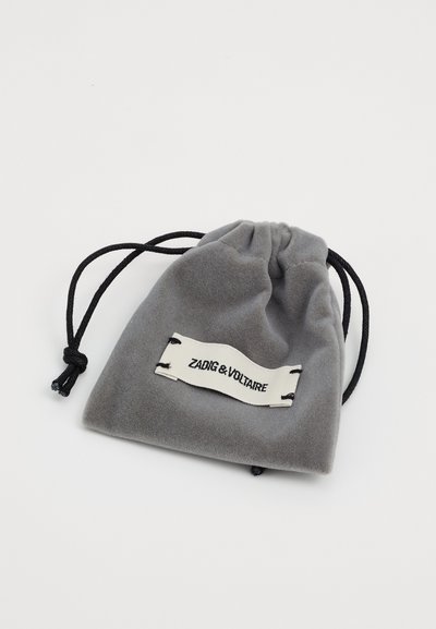 Pungă cu șnur din catifea gri, cu șnururi negre și o etichetă albă pe care este imprimat "ZADIG & VOLTAIRE" în negru. Textură netedă, finisaj moale.