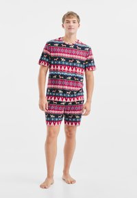 Korte mouwen pyjama set met patronen van bomen, vossen en geometrische vormen in rood, blauw en wit; gemaakt van zachte stof en met een relaxte pasvorm.