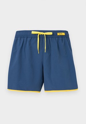 Shorts de bain bleu marine avec cordon de serrage jaune, bordure jaune le long de l'ourlet et logo « Moschino » sur la ceinture.