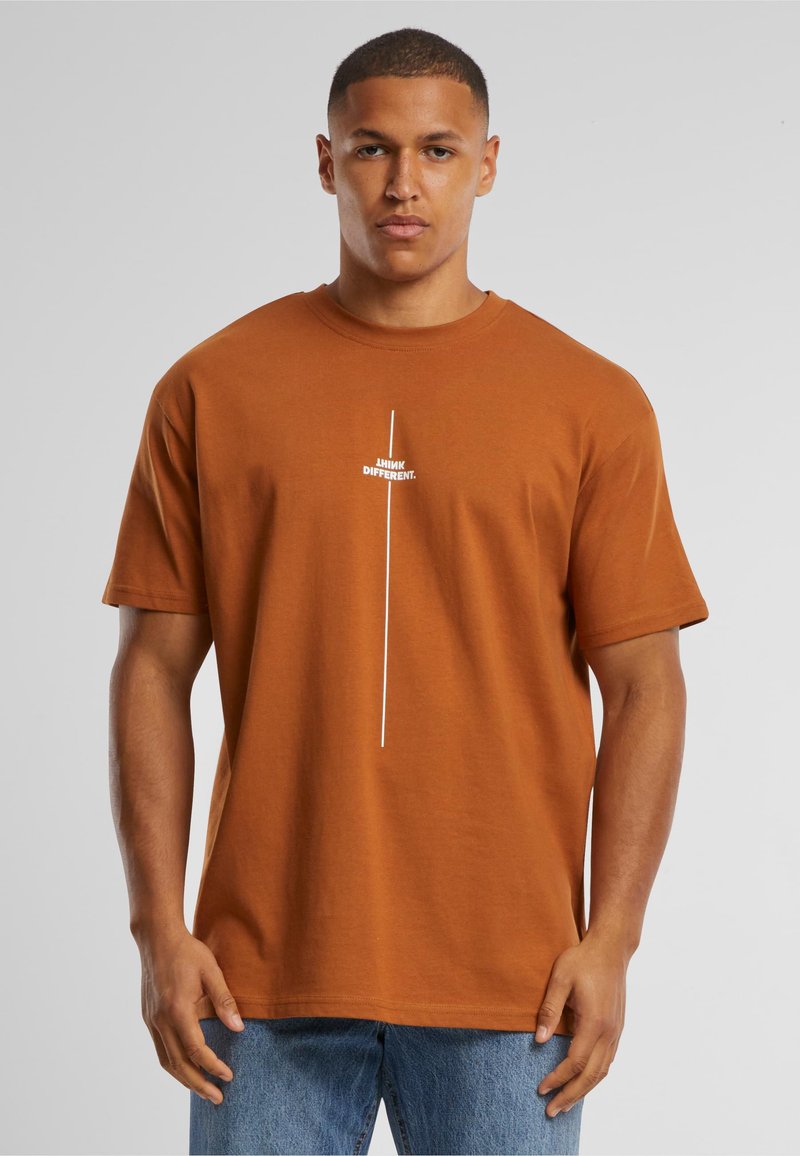 Bruine katoenen T-shirt met korte mouwen, met een witte tekstgrafiek "THINK DIFFERENT" verticaal gecentreerd op de voorkant.
