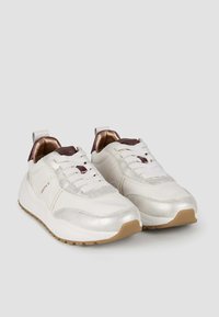 Sneaker bianchi con accenti argentati metallici, superfici texturizzate e suole in gomma. Presentano un collare imbottito e una chiusura con lacci.