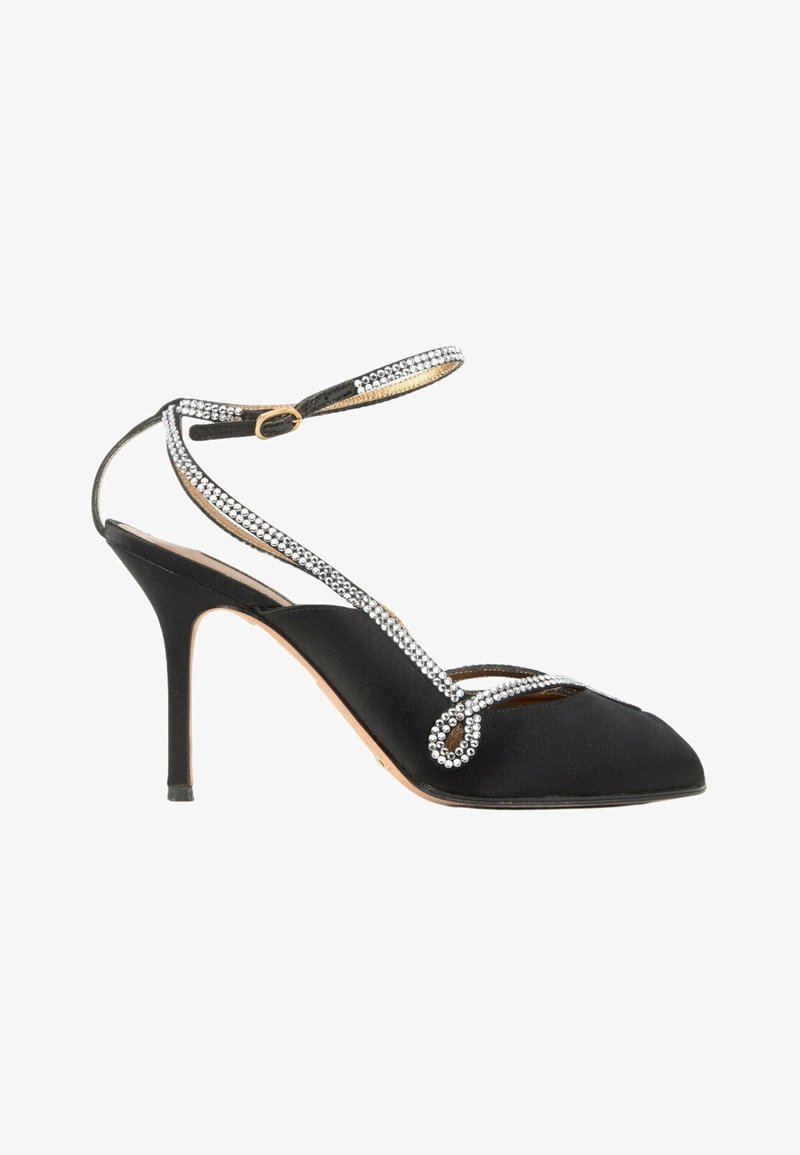 Chaussure noire à talon haut avec bout pointu, bride à la cheville et chaînes décoratives en strass entourant le pied et la cheville.