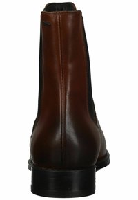 Stivali ankle in pelle marrone con pannelli laterali elasticizzati, una texture liscia, accenti neri a contrasto e un tacco basso a blocco.