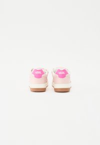 Sneakers med en glat pink overdel, hvid mellemsål og sål af gummi. Har et fremtrædende pink logo på hælen og et afrundet design.