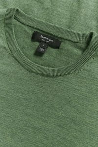 Roheline meriinovillane kampsun ümara kaelusega, ribaga servadega ja sildiga, mis näitab brändi ja materjali infot.