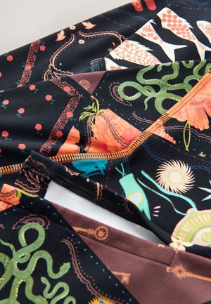 Mehrfach gemusteter Stoff mit schwarzem Hintergrund und lebendigen Designs, die florale, aquatische und geometrische Motive zeigen. Die Kontrastnähte sind orange.