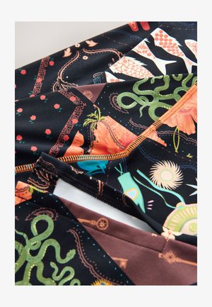 Večvzorec tkanine z umetnim črnim ozadjem in živahnimi dizajni, ki vključujejo cvetlične, vodne in geometrijske motive. Kontrastni šivi so oranžni.