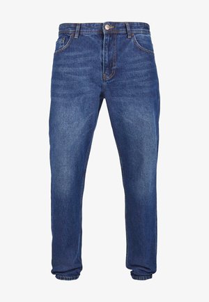 Tumed sinimustad teksad sirge säärega. Omab viit taskut, vöökohagoone ning esimest nööbikeskust.