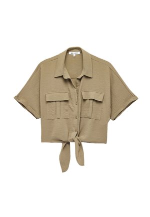 Camisa corta de manga corta en tejido marrón claro, con un cierre de botones en la parte delantera, dos bolsillos en el pecho y un detalle de dobladillo atado.