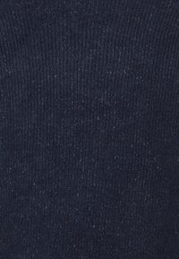 Tummansininen ribbikuvioitu neulekangas, jossa on hieno rakenne ja hienovaraisia sävyeroja, sekä sileä pinta. Ihanteellinen vaatteisiin tai asusteisiin.