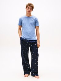 T-shirt di cotone azzurro chiaro con scollatura rotonda, abbinato a pantaloni del pigiama blu navy con un motivo colorato.