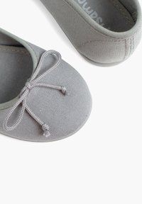 Ballerine in tessuto grigio con punta rotonda e un fiocco decorativo sul davanti. Texture liscia, design semplice e silhouette a profilo basso.