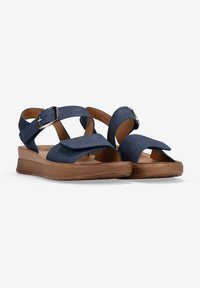 Navy blue sandals with cross straps, adjustable buckle, and a brown textured sole. Features soft material and open-toe design.