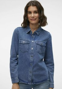 Jeanshemd in mittelblauer Farbe, mit langen Ärmeln, durchgehendem Knopfverschluss, zwei Brusttaschen und einem klassischen Kragen mit gestickten Details.