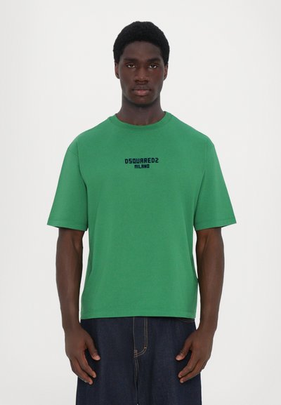 T-shirt verde a maniche corte realizzato in cotone con colletto rotondo. Presenta un logo stampato "DSQUARED2 MILANO" in nero centrato sul petto.