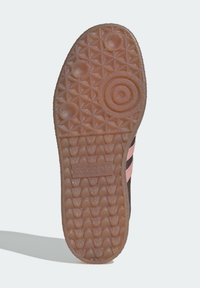 Shoe sole with textured gum rubber tread, circular and triangular patterns, and Adidas logo embossed in the center.