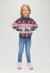 Pull en laine violet foncé avec des motifs d'arbre rose et de licorne. Associé à un jean bleu et des baskets pastel, offrant un look confort et ludique.