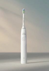 Brosse à dents électrique avec un manche ergonomique blanc, un bouton d'alimentation et une tête de brosse colorée avec un design vert et bleu.