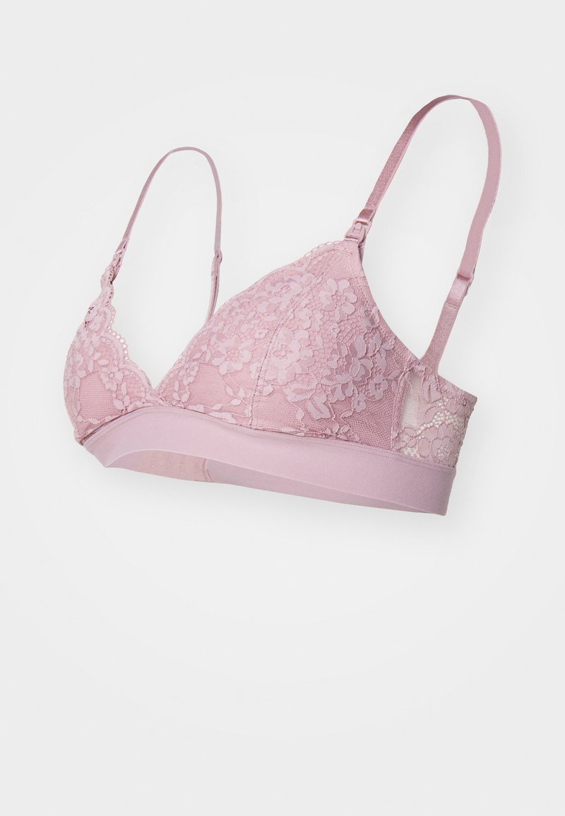 Vaaleanpunainen pitsinen bralette, jossa on kukkakuvioita, säädettävät olkaimet ja kiinteä vyö. Pehmeä tekstuuri ja kolmiomainen muoto.