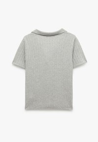 Grå polo-shirt med korte ærmer, der har et struktureret, ribbet mønster og en krave. Stoffet virker blødt og let.