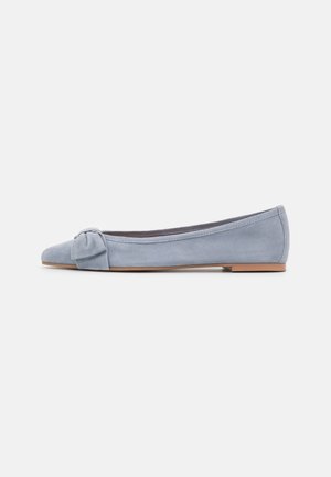 Chaussure plate en daim bleu clair avec bout pointu et nœud décoratif sur le dessus, vue de côté sur un fond blanc uni.