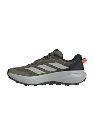 Olivgrüner und schwarzer Laufschuh mit weißen Streifen, dicker weißer Sohle und orangefarbener Fersenzuglasche, von der Seite gezeigt.
