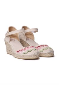 Bežinės espadrilės su aukštu kulnu ir kulkšnies dirželiu, puikuojasi daugiaspalviu zigzagu siuvinėjimu rožinės ir žalios spalvų, džiuto aptrauktu padu.