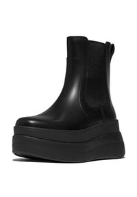 Black platform ankle boots with a glossy leather exterior, elastic side panels, and a thick rubber sole for added height and stability.