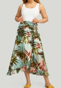 Jupe maxi florale avec un fond bleu clair, motif de feuilles de palmier vertes et roses, bordure froncée et taille élastique pour plus de confort.