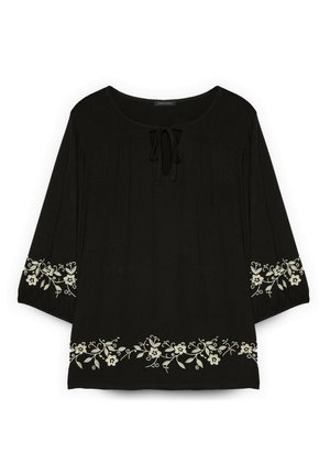 Schwarze Bluse mit langen Ärmeln und rundem Halsausschnitt mit Schleife, mit weißer Blumenstickerei entlang des Saums und der Ärmelbündchen.
