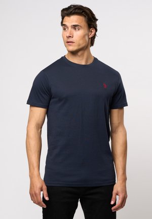 Marineblå bomulds T-shirt med korte ærmer, rund hals og et lille rødt logo på brystet. Glat tekstur, enkelt design.