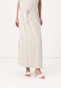 Stripes maxi kjole i beige med marineblå vertikale striper, elastisk midje, justerbar snor, sideslitt, kombinert med kremfargede hæl mules.