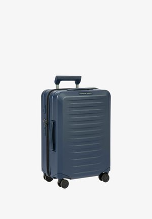 Valigia rigida blu navy con scanalature verticali, doppie ruote, maniglia estensibile e chiusura lampo. Presenta un design elegante e moderno.