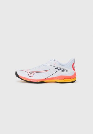 White athletic shoes with red and orange accents, mesh upper, black rubber sole, and visible cushioning in the heel for support.